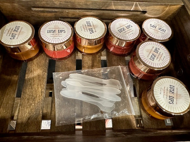 Set of lip balm containers with 'Lush Lips' branding on a wooden surface.